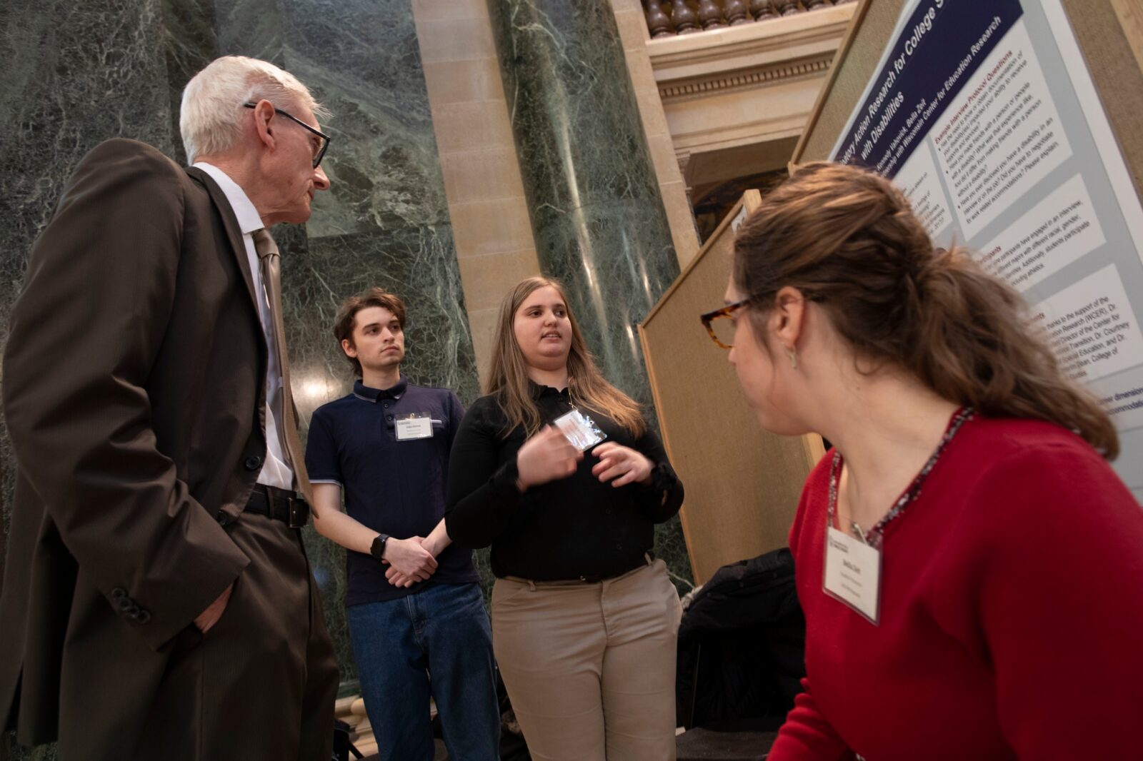three students presenting on disability advocacy to Governor Tony Evers